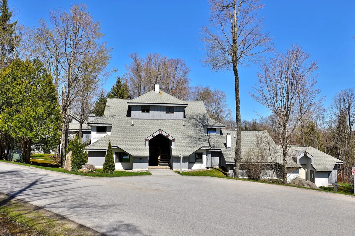 This exterior shot captures the main entrance of the building with its unique roof design and a beautifully landscaped garden. The steps and porch area suggest a welcoming arrival and offer hints of outdoor comfort, ideal for guests coming or going after a day of adventure in Killington.